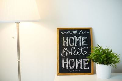Home sweet home written on chalkboard next to lamp